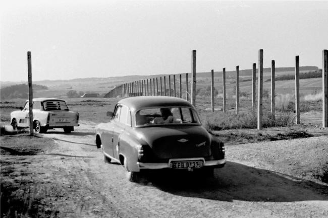 Durch ein Schlupfloch in den Westen: Wie hier im Vogtland wollten nach dem 9. November 1989 viele nicht mehr warten und fuhren mit ihrem Trabi oder Wartburg quasi illegal in den Westen. Die DDR existierte ja noch, eine Kontrolle an der Grenze hätte es also geben müssen. Schnell waren in diesen Herbsttagen provisorische Straßen entstanden, die durch die Grenzsicherungsanlagen führten. Tausende neugierige DDR-Bürger nutzten diese Schlupflöcher für einen Ausflug zu den Nachbarn auf der anderen Zaunseite.