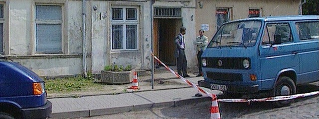 Zwei Männer hinter Absperrband auf einer Treppe vor einer Sparkasse