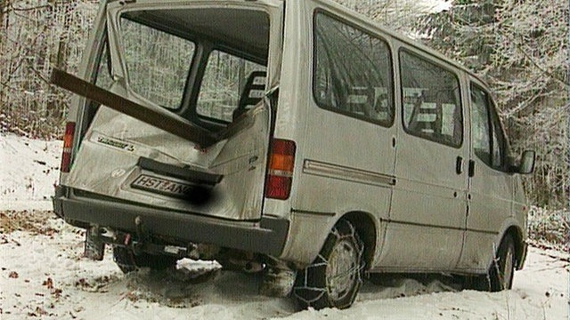 Ein weißer Transporter mit beschädigter Heckklappe im Schnee